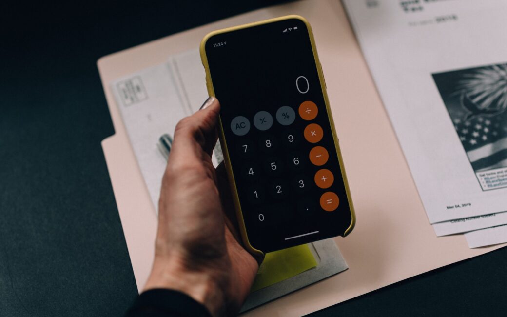 hand holding calculator symbolising tax